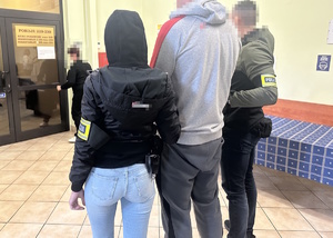na zdjęciu dwóch nieumundurowanych policjantów trzyma zatrzymanego mężczyznę