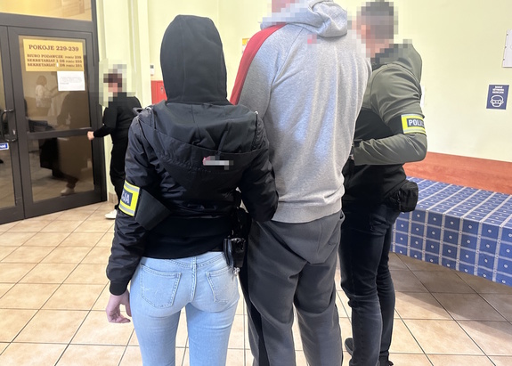 na zdjęciu dwóch nieumundurowanych policjantów trzyma zatrzymanego mężczyznę