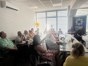 na zdjęciu seniorzy-uczestnicy debaty, strażnik miejski i umundurowany policjant
