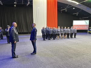 na zdjęciu dowódca pododdziału policjantów składa meldunek komendantowi wojewódzkiemu policji na uroczystości w obecności pododdziału i orkiestry