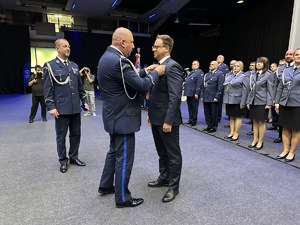 na zdjęciu komendant wojewódzki policji przypina odznaczenie zastępcy prezydenta miasta