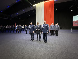 na zdjęciu umundurowani policjanci i odznaczony mężczyzna
