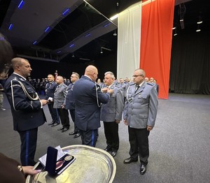na zdjęciu komendant wojewódzki wręcza odznaczenie policjantowi