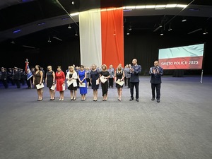 na zdjęciu wyróżnieni pracownicy cywilni z listami gratulacyjnymi, a obok komendanci policji bijący brawo