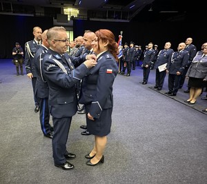na zdjęciu przedstawiciel związków zawodowych policji wręcza odznaczenie policjantce