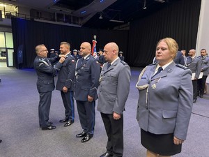 na zdjęciu przedstawiciel związków zawodowych wręcza odznaczenie policjantowi