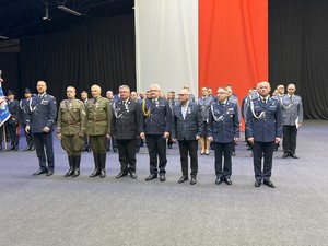 na zdjęciu uhonorowani goście uroczystości stoją w rzędzie wraz z umundurowanymi policjantami