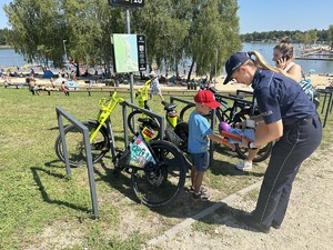 na zdjęciu umundurowana policjantka przekazuje opaskę odblaskową dziecku