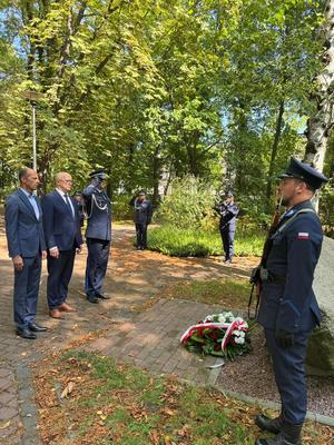 Zdjęcie przedstawia przedstawicieli miasta Jaworzna wraz z Komendantem Miejskim Policji w Jaworznie insp. dr Piotrem Uwijałą, którzy oddają honor przed obeliskiem „Pamięci Funkcjonariuszy 7. Kompanii Rezerwy Policji Państwowej&quot;, obok którego pełni wartę honorową dwóch funkcjonariuszy Policji