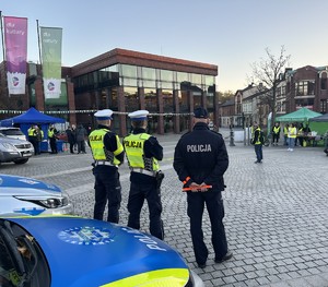 na zdjęciu umundurowani policjanci przy radiowozie