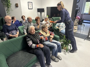 na zdjęciu policjantka rozdaje seniorom odblaski