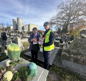 na zdjęciu policjantka z kobietą przy grobie