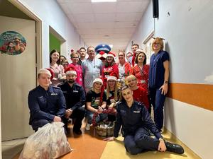 zdjęcie grupowe policjantów, personelu szpitala oraz maskotki policji - sznupka
