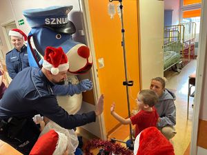 na zdjęciu policjant przybija piątkę z małym pacjentem