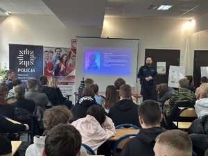 na zdjęciu policjant w mundurze prowadzi prelekcję dla młodzieży