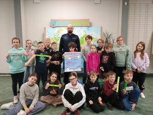 zdjęcie grupowe umundurowanego funkcjonariusza z dziećmi z półkolonii