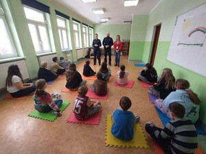 umundurowaniu funkcjonariusze i przedstawicielka sanepidu prowadzą prelekcje z dziećmi - uczestnikami półkolonii