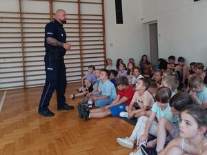 na zdjęciu policjant umundurowany prowadzi prelekcję w szkole